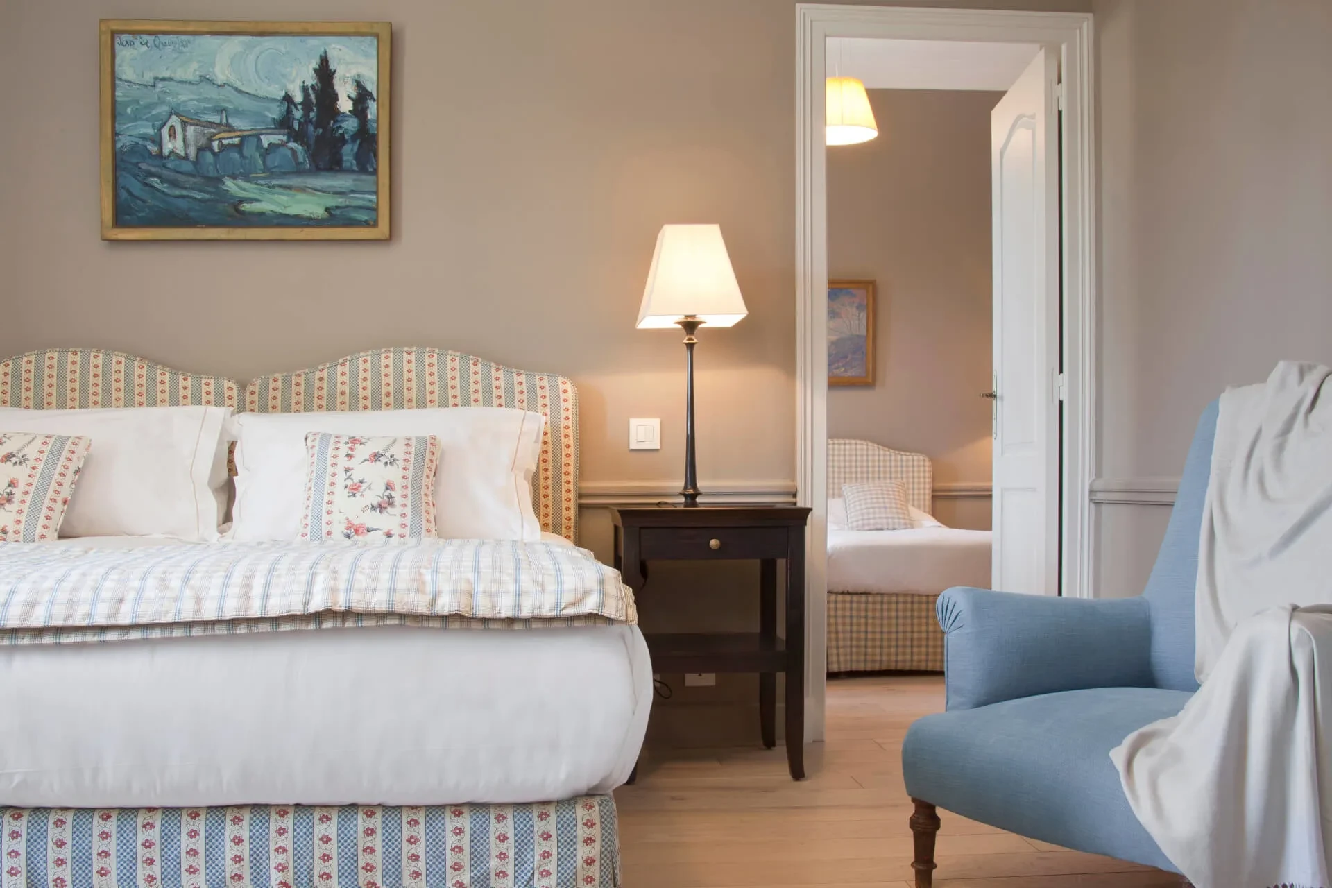 Chambre élégante avec lits et fauteuils.